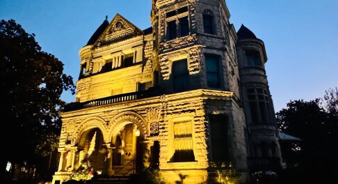 Conrad-Caldwell House lit up at night in Old Louisville