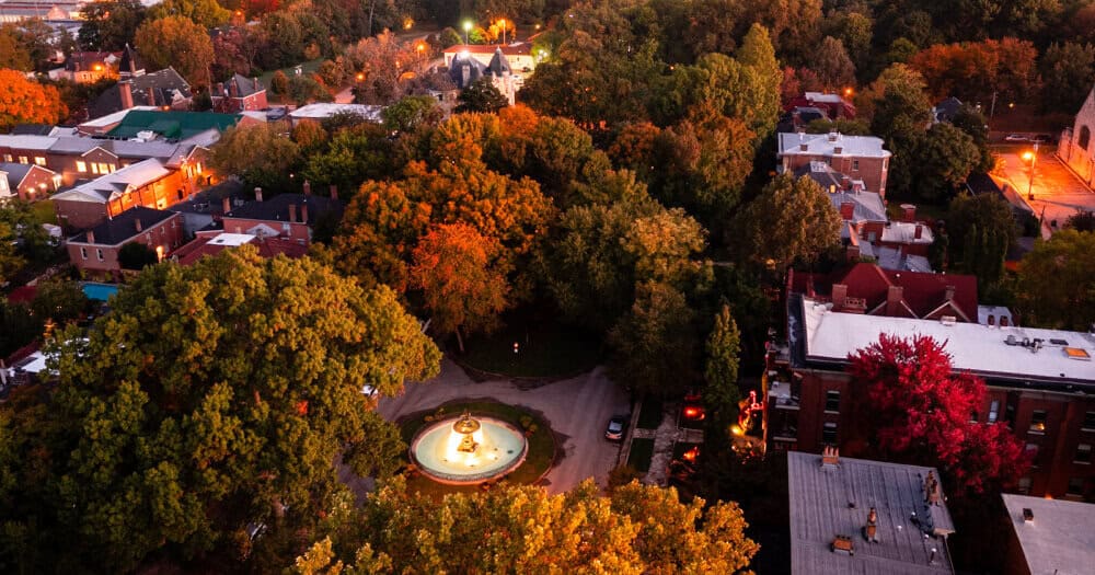 Aerial view of St. James Court fountain and Old Louisville in fall with the downtown Louisville skyline.