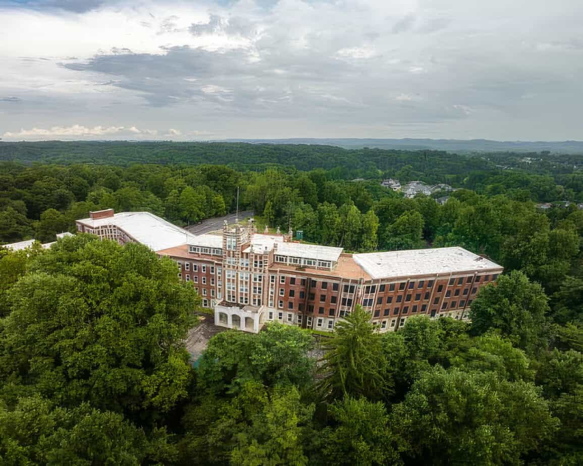 Aerial view of Waverly Hills Sanatorium in Louisville, Kentucky, surrounded by trees.